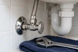 Household water supply valve with a braided hose and adjustable wrench